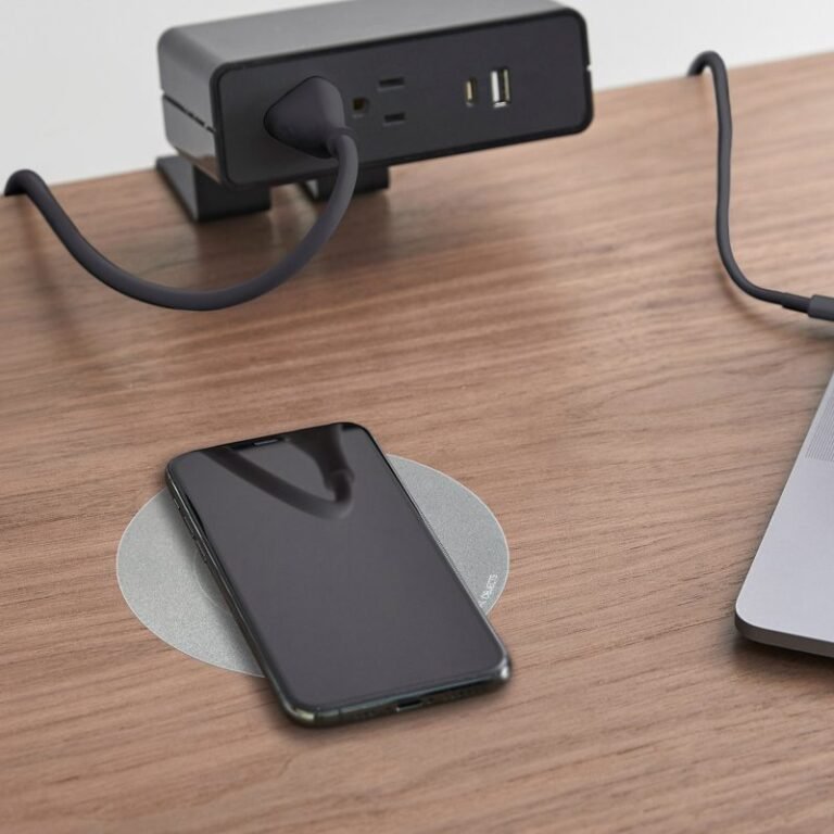 Wireless charging pad with a phone charging on a wooden desk