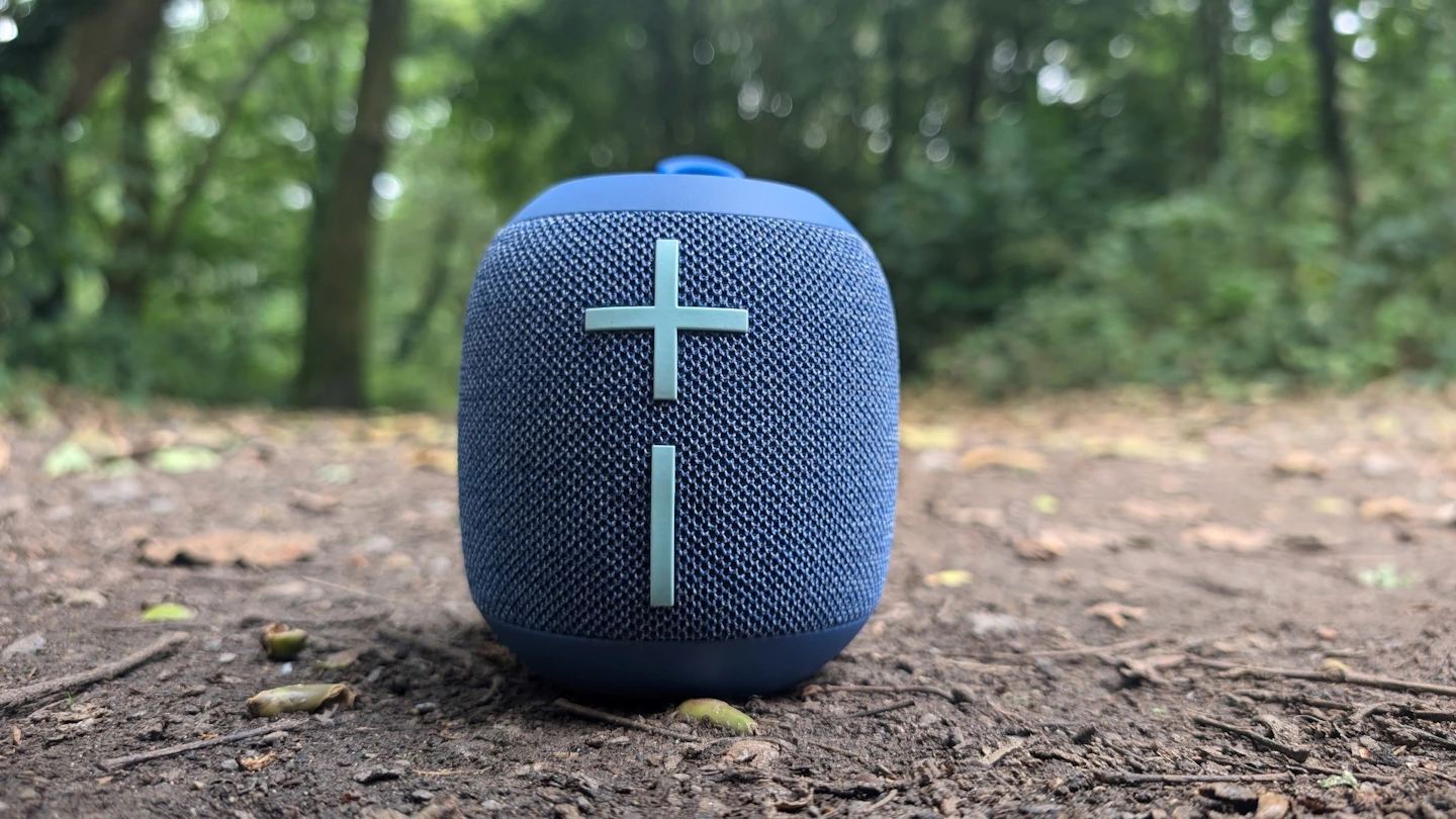 Compact Bluetooth speaker placed outdoors on the ground