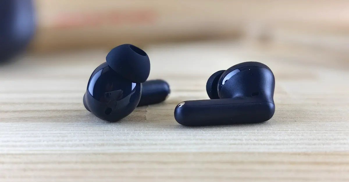 Wireless earbuds in their charging case on a desk